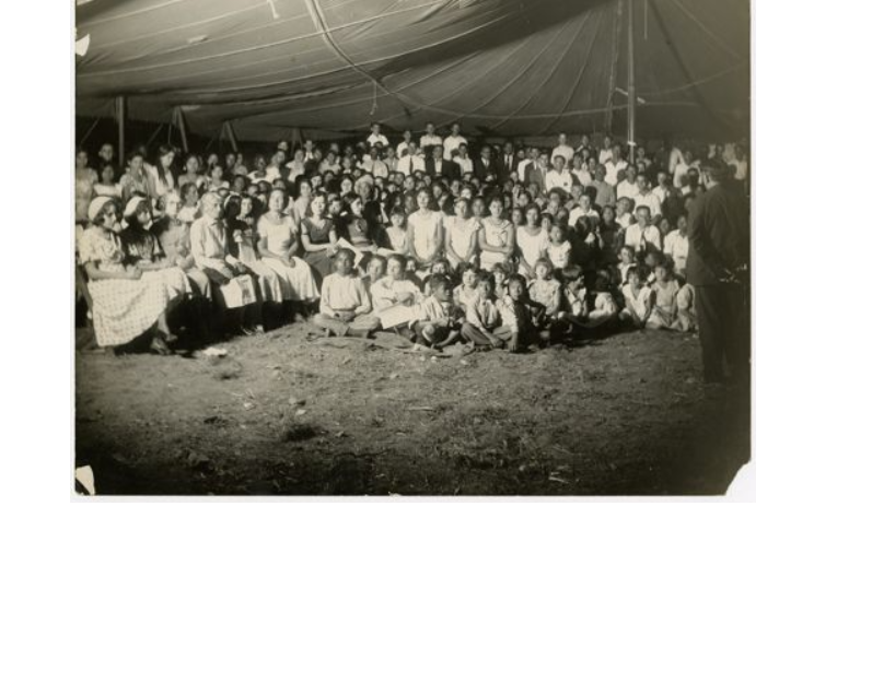 image showing a missionary gathering. This photo is packed with people, children and adults alike.